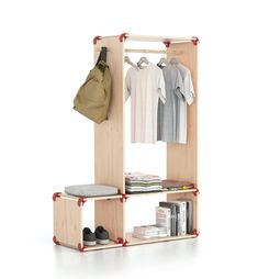 an open closet with clothes hanging on the rack and bookshelf below it, next to a backpack