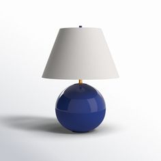 a blue table lamp with a white shade on it's base and a light bulb in the middle