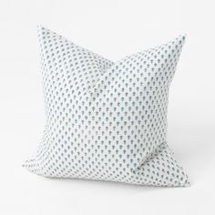 a blue and white pillow on a white background