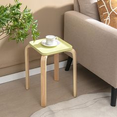 a small table with a cup on it next to a couch