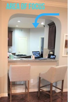 an open laptop computer sitting on top of a counter next to two bar stools