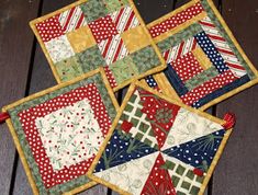 four quilted placemats sitting on top of a wooden table