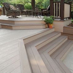 a wooden deck with steps leading up to an outdoor dining area