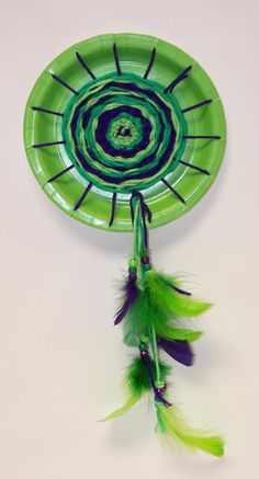 a green plate with feathers hanging from it