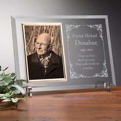 an old man's portrait is placed on a desk next to a potted plant