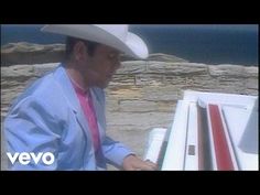 a man in a cowboy hat is playing the piano