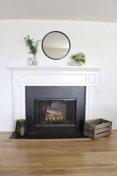 a fire place with a mirror above it