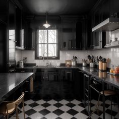 a black and white kitchen with checkered flooring