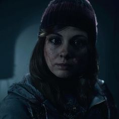 a woman in a dark room looking at the camera with an evil look on her face