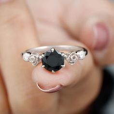 a person holding a black diamond ring in their hand