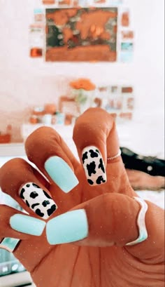 a woman's hand with blue and white nail polish