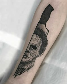 a person with a knife in their hand and a face on the arm that has been drawn