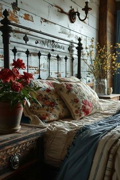 a bed with pillows and flowers on it in a bedroom next to a wooden wall