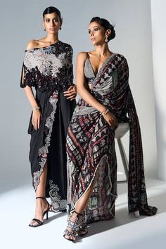 Black one shoulder asymmetric cape with kantha embroidered checkered floral motifs with sequin and bead embellishments, 3D sequin flowers. Comes with embellished pre-draped skirt saree. - Aza Fashions Designer Black Draped Saree, Designer Saree Dress With Draped Sleeves, Traditional Draped Sequin Dress, Elegant Draped Designer Dresses, Evening Saree Dress With Draped Sleeves, Reception Dress With Traditional Draped Sleeves, Black Pre-draped Party Saree, Pre-draped Dupatta Dress For Reception, Traditional Drape Dress With Draped Sleeves For Reception