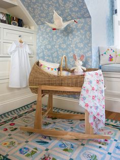 a baby's crib in the corner of a room with blue wallpaper