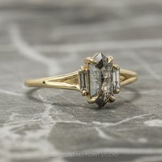 a three stone diamond ring on a marble surface