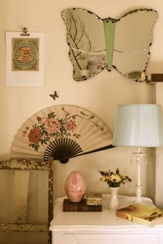 a white table topped with a lamp next to a mirror