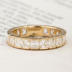 These old-style, open-culet asscher cuts were begging to be set into a band - so obviously, we had to oblige! With warm, yellow gold half bezels these diamonds look absolutely stunning. They are shimmery and sparkly, packing a big punch in a classic way. At the bottom of the band is what we call a sizing bar : not to only there to help prevent damage to any palm-side diamonds, but also to allow for some sizing if need be! A perfect stacker, killer band, and new favorite in your jewelry box. 18kt Antique Eternity Band, Asscher Cut Wedding Band, Luxury Rose Cut Diamonds Eternity Band For Formal Events, Luxury Octagon Diamond Ring With Single Cut Diamonds, Classic Gold Eternity Band With Rose Cut Diamonds, Gold Octagon Diamond Ring With Single Cut Diamonds, Classic Gold Emerald Cut Eternity Band, Gold Emerald Cut Diamond Eternity Band, Asscher Cut Eternity Band With Diamond Accents