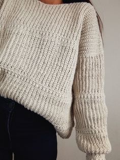 a close up of a person wearing a sweater with long sleeves and an open back