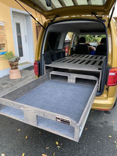 the back end of a yellow van with its cargo compartment open and it's flatbed opened