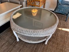 a wicker coffee table with glass top in a living room