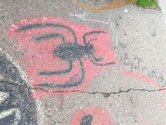 a sidewalk with graffiti on it next to a potted plant