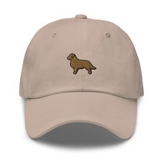 "Upgrade your style with our Golden Retriever Dad Hat. Made from comfy cotton, it offers a perfect fit with an adjustable design. The adorable Golden Retriever embroidery adds warmth and playfulness, making it a must-have for dog lovers. Elevate your look effortlessly - grab your cap today! * Utilizes 100% chino cotton twill in its construction * The Green Camo version incorporates 35% chino cotton twill and 65% polyester * Unstructured, low-profile design with 6 panels * Product adorned with an embroidered design * Features 6 embroidered eyelets for improved airflow * 3 ⅛\" (7.6 cm) crown for comfort * Adjustable strap with an antique buckle for customization * Blank product responsibly sourced from either Vietnam or Bangladesh" Embroidered Cotton Trucker Hat With Flat Bill, Embroidered Cotton Dad Hat With Flat Brim, Cotton Embroidered Flat Bill Hat, Brown Cotton Trucker Hat With Embroidered Logo, Cotton Baseball Cap With Embroidered Logo, Gold Embroidered Cap Hat, Golden Retriever Embroidery, Outdoor Six-panel Dad Hat With Embroidered Logo, Gym Hat