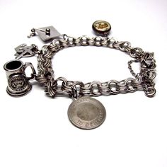 "Vintage charm bracelet. Midcentury, sterling silver charm bracelet, triple interlocking links. 5 vintage charms: aries ram, hope faith charity, Cortland mug, graduate cap and a date to remember charm. The piece dates from about the 1960s. The bracelet has a wide, sliding clasp that is marked: \"JMS STERLING\" The design is one of 3 rings linked to 3 rings (and so on.) Length of Bracelet: 8\" or 20.3 cm All of the charms, as well as the bracelet are silver, or have silver components, but not all Luxury Silver Charm Bracelet With Vintage Charm, Classic Charm Bracelet With Vintage Charm As Gift, Antique Nickel-free Charm Bracelet Collectible, Vintage Sterling Silver Bracelet With Charm, Heirloom Silver Bracelet With Vintage Charm, Vintage Engraved Charm Bracelet Gift, Vintage Silver Engraved Charm Bracelet, Vintage Antique Silver Charm Bracelet As Gift, Vintage Antique Silver Charm Bracelet Gift