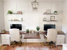 a home office with two computer desks and an orange area rug on the floor