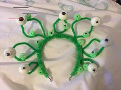 a group of fake eyeballs on top of a white sheet with green thread and plastic eyes