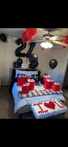 a table with red and white gift bags on it, balloons in the shape of hearts