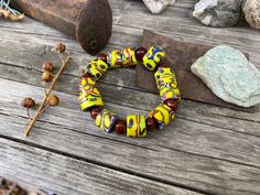 "these type of glass beads were traded in the                         1800's from africa to venice . . .old rare beads       the detail of the designs is amazing !!     called \"millefiore\" meaning thousand flowers  the vibrant colors last forever          the big trade beads in this stretch bracelet are all  of the same design - a strong, bright yellow       and deep maroon wine red with a bit of blue . . .     alternating with high quality carnelian rounds        strung on sturdy clear elasti Traditional Stretch Bracelet With Large Beads, Artisan Multicolor Stretch Bracelet With Round Beads, Artisan Yellow Beaded Bracelets With Large Beads, Colorful Beads Stretch Bracelet, Artisan Multicolor Round Beads Stretch Bracelet, Artisan Stretch Bracelet For Jewelry Making With Large Beads, Handmade Yellow Stretch Bracelet For Spiritual Style, Stretch Bracelet With Large Czech Glass Beads, Artisan Czech Glass Beaded Bracelets With Spacer Beads