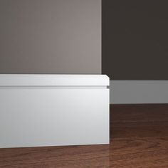 an empty white box sitting on top of a hard wood floor next to a wall