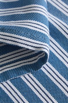 a close up view of a blue and white striped shirt with stripes on the fabric