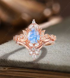 an engagement ring with a blue topazte surrounded by white and rose gold accents