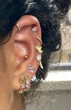 a woman's ear with multiple piercings on it