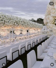 the tables are set with white flowers and place settings for guests to sit down at