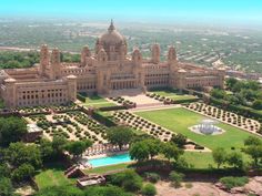 an aerial view of a large building in the middle of trees and bushes, surrounded by greenery