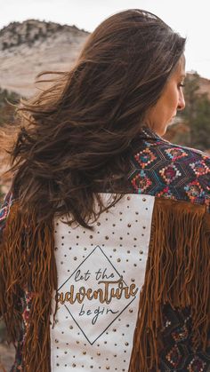 a woman with long hair wearing a jacket that says, not the adventure is yet