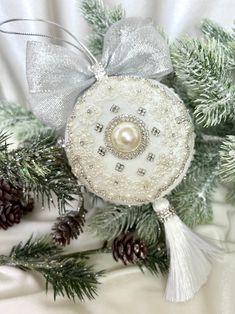 a white ornament hanging from a christmas tree