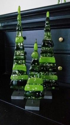 two green christmas trees sitting on top of a table