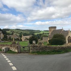 an old stone church in the middle of a rural area with green grass and trees