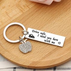 a keychain with a heart on it that says drive safe, i need you here with me