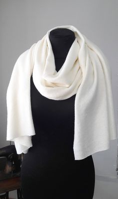 a black mannequin wearing a white scarf