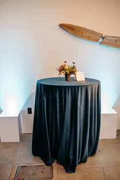 a table with a surfboard on the wall behind it