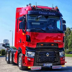 a red semi truck driving down a road