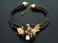 "Gorgeous Vintage Mixed Materials Jewelry Black Fabric Rope Cord Plastic Gold Tone Rhinestones Flower Leaf Chunky Choker Bib Necklace and Clip on Back Earrings Set Gothic Wedding Jewelry Necklace measures approx 17-1/2\" long by 3/4\" wide and the center flower/leaf is 3-1/4\" by 2-1/4\" at the widest point. Each earring measures 1-3/4\" by 2\" at the widest point. For more brand names of vintage jewelry and accessories please see our \"High End Vintage Jewelry\" Shop Section: https://www.etsy.c Black Floral Jewelry For Formal Occasions, Black Flower-shaped Formal Jewelry, Formal Black Flower Jewelry, Formal Black Flower-shaped Jewelry, Black Flower-shaped Jewelry For Wedding, Black Flower-shaped Wedding Jewelry, Black Flower Shaped Wedding Jewelry, Black Costume Jewelry Necklaces For Wedding, Black Flower Jewelry For Party