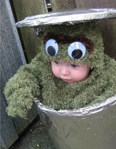 a small child wearing a green costume with googly eyes and a tinfoil hat