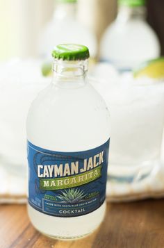 a bottle of cayman jack margarita sits on a table next to a plate