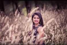 a woman standing in the middle of tall grass